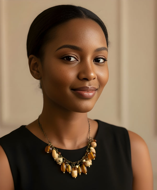 قلادة مصنوعة يدويًا من الخرز بلون الصدف والعنبر مع سلسلة فضية.